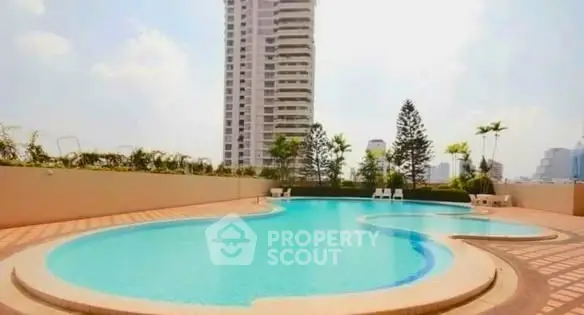 Luxurious high-rise building with a stunning outdoor pool and city views, perfect for urban living.