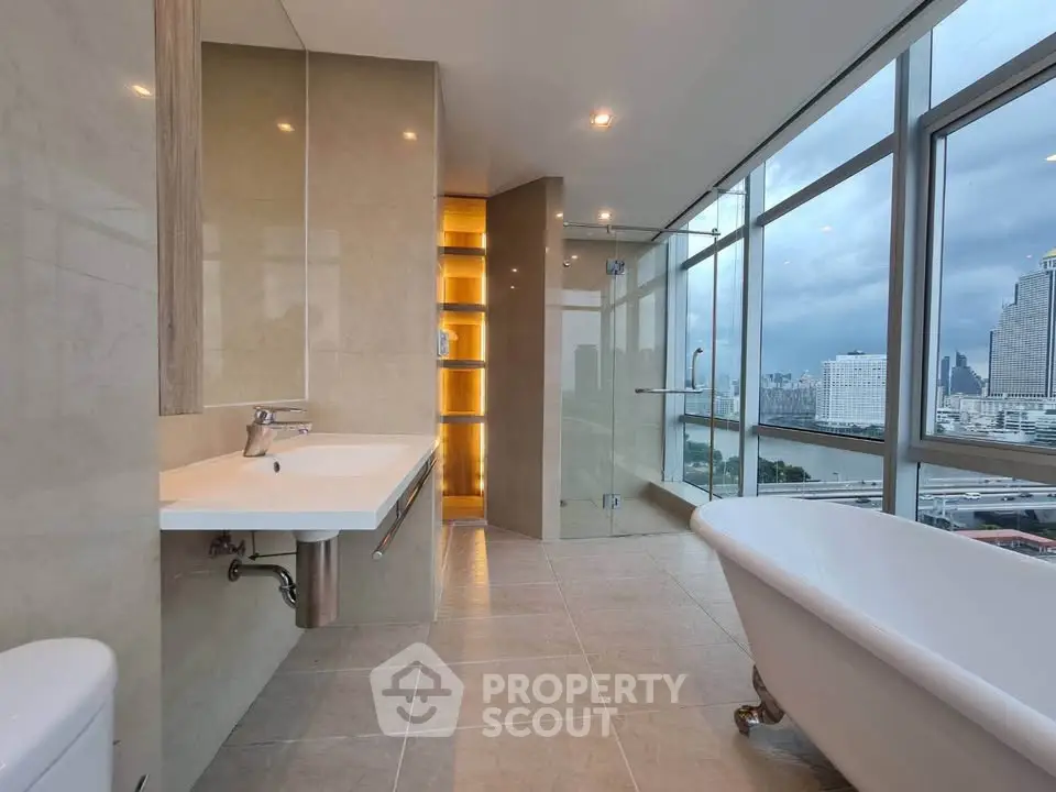 Luxurious bathroom with city view, featuring a freestanding bathtub and modern fixtures.
