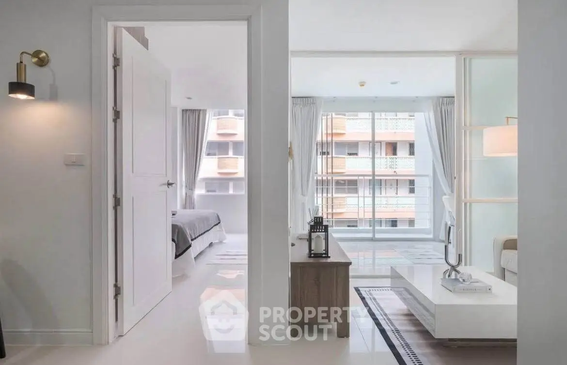Modern apartment interior with open living room and bedroom, featuring sleek design and large windows.