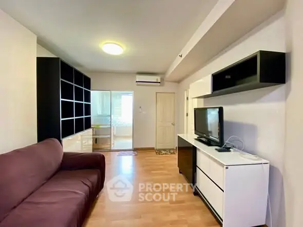 Spacious living room with modern furniture and wooden flooring in a cozy apartment.