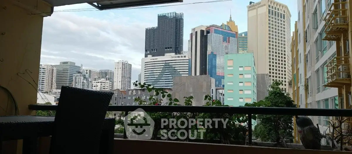 Stunning cityscape view from a cozy balcony with modern high-rise buildings.