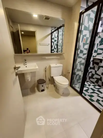 Modern bathroom with geometric tile shower and sleek fixtures
