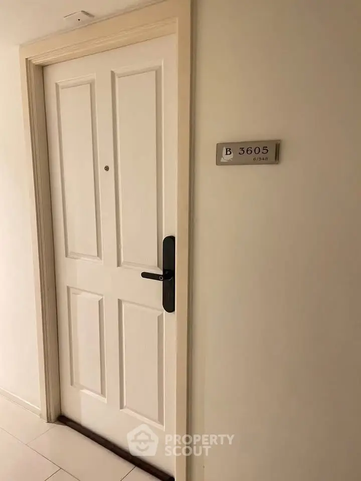 Elegant apartment entrance with modern door and unit number plaque, showcasing secure and stylish living.