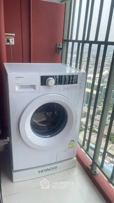 Modern washing machine on high-rise balcony with city view