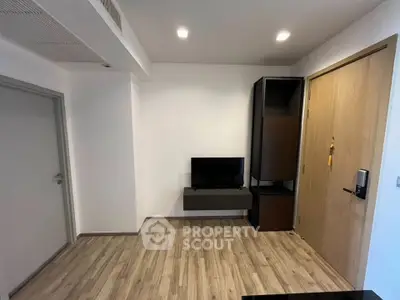 Modern minimalist living room with wooden flooring and wall-mounted TV