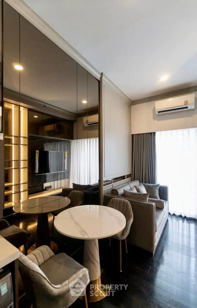 Modern living room with elegant furniture and large windows for natural light.