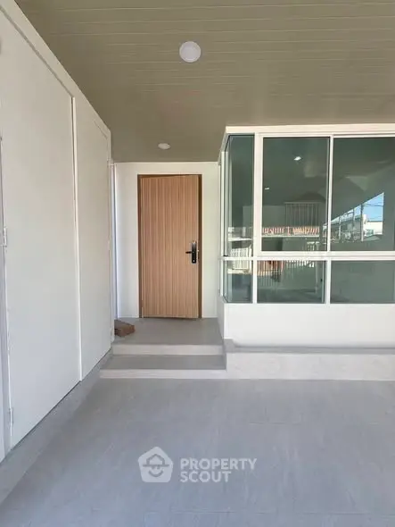 Modern entrance with sleek wooden door and large glass windows