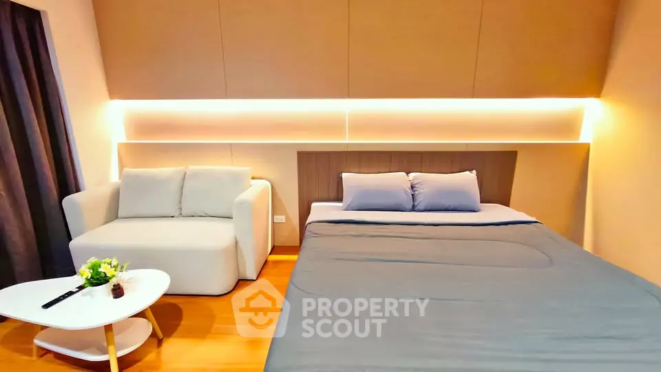 Modern bedroom with cozy sofa and stylish lighting