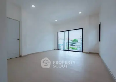 Spacious empty room with large sliding glass doors leading to a balcony, perfect for customization.