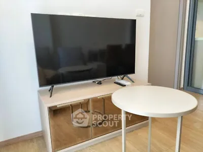 Modern living room with sleek TV stand and round table, perfect for cozy entertainment.