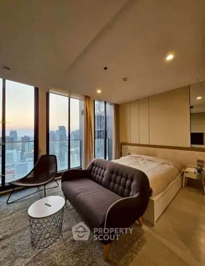 Luxurious bedroom with stunning city view and modern furnishings in high-rise apartment.