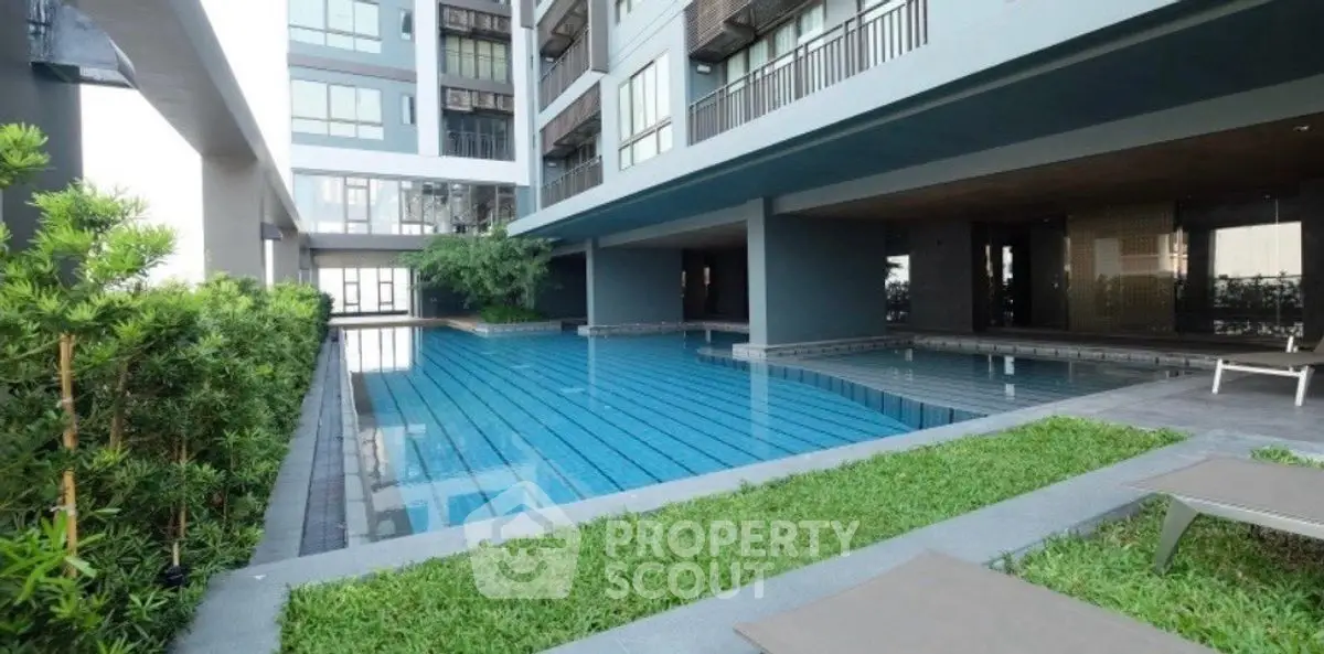Luxurious modern apartment complex with stunning pool and lush greenery.