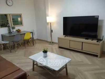 Modern living room with stylish furniture and large TV, perfect for relaxation and entertainment.