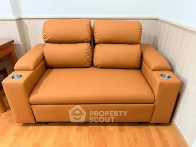 Stylish brown leather sofa with cup holders in cozy living room corner