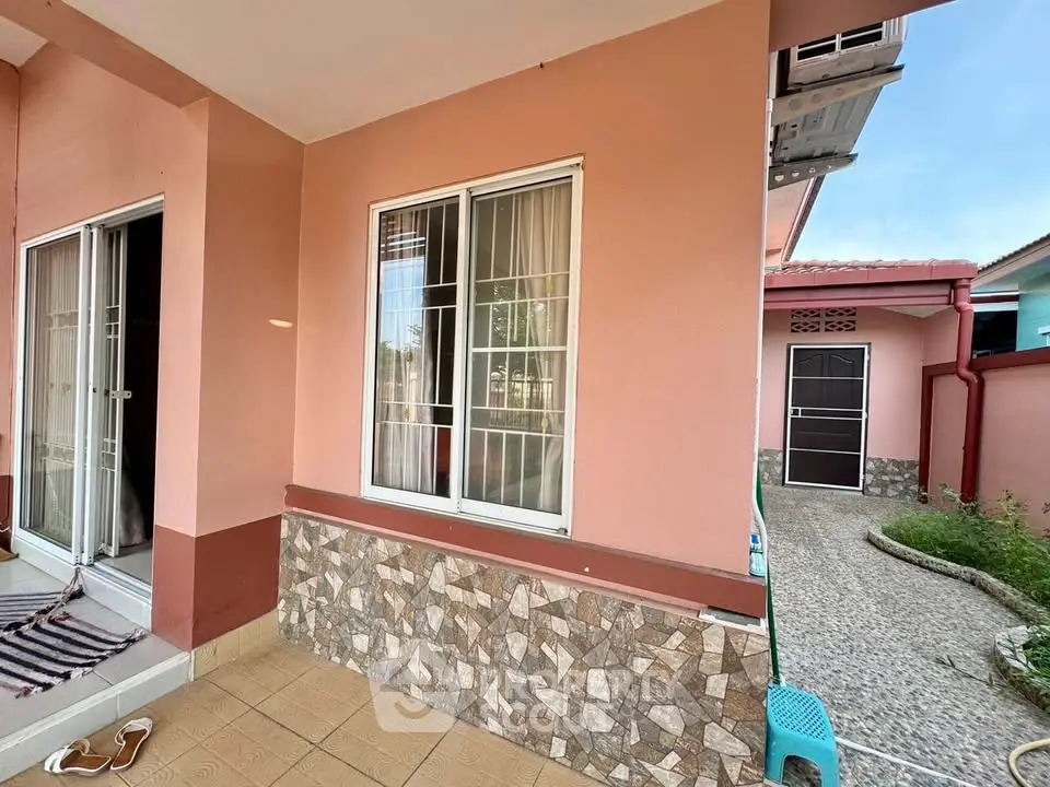 Charming exterior view of a cozy home with tiled patio and inviting entrance.