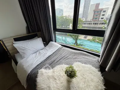 Cozy bedroom with stunning pool view, featuring modern decor and large windows for natural light.