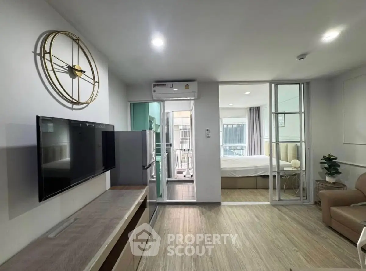 Modern open-plan living room with stylish decor and adjacent bedroom view.