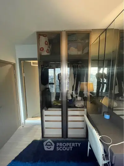 Modern bedroom with sleek wardrobe and desk, city view reflection in mirror