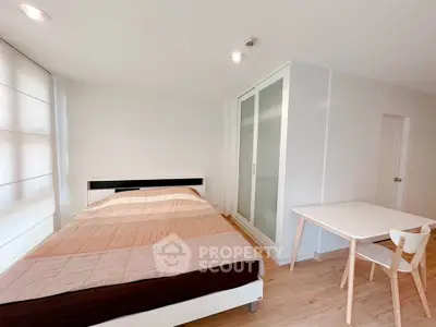 Bright and cozy bedroom with modern furnishings and ample natural light.