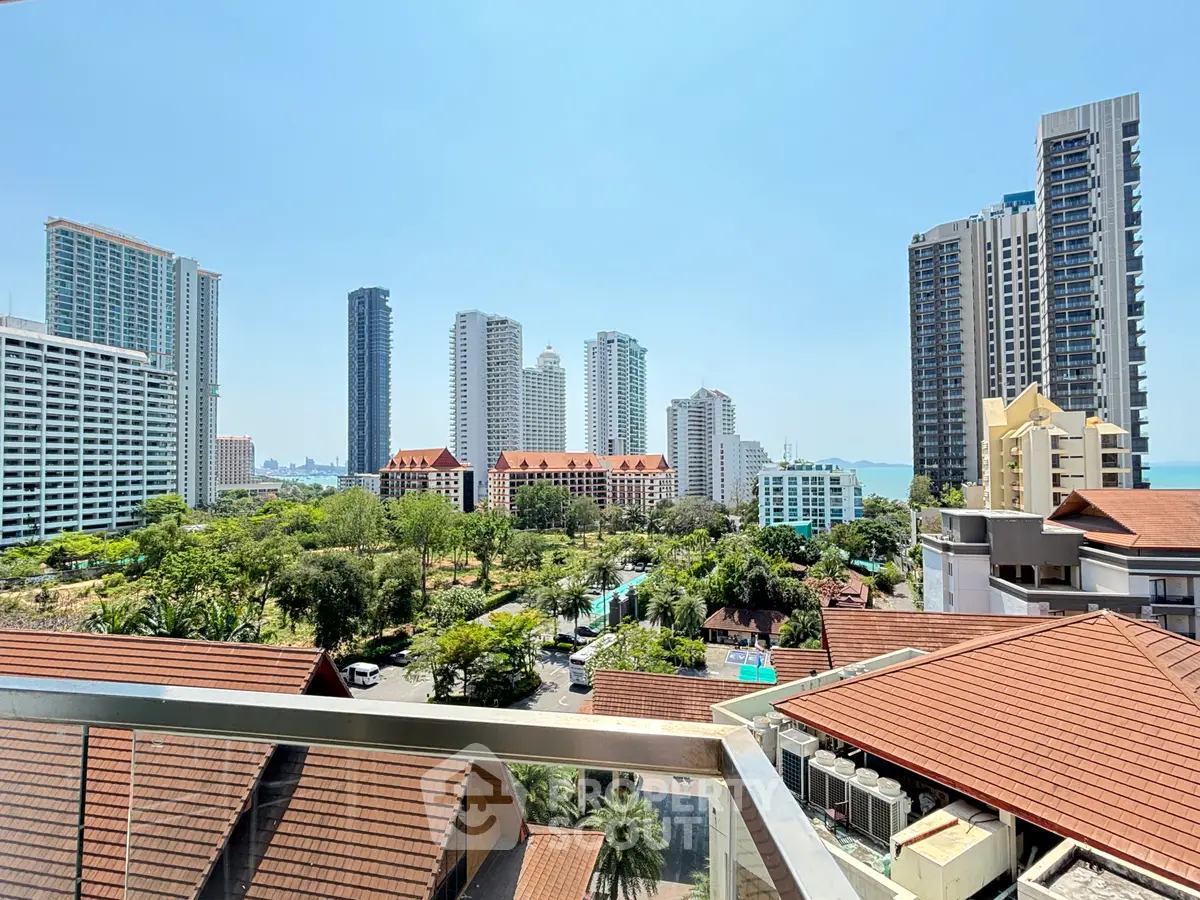 Stunning cityscape view from a high-rise balcony overlooking modern skyscrapers and lush greenery.