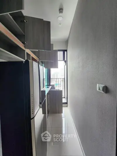 Modern kitchen with sleek cabinets and glossy floor, featuring a compact layout and ample natural light.