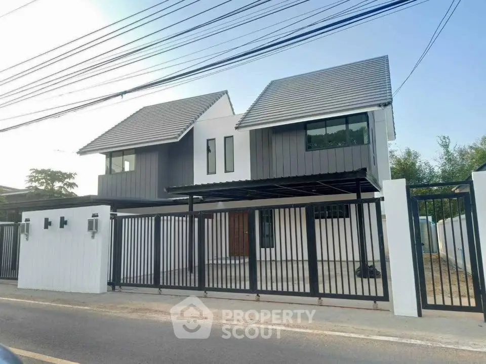 Modern two-story house with sleek design and gated entrance, perfect for contemporary living.