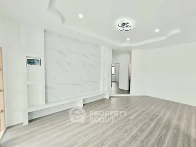 Spacious modern living room with elegant flooring and stylish ceiling lights.