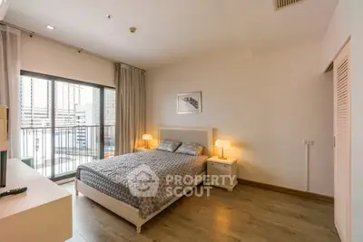 Spacious bedroom with modern decor and large window offering city views