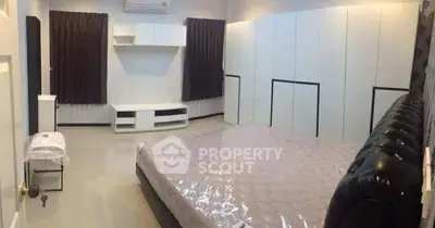 Spacious modern bedroom with sleek white cabinetry and elegant decor.