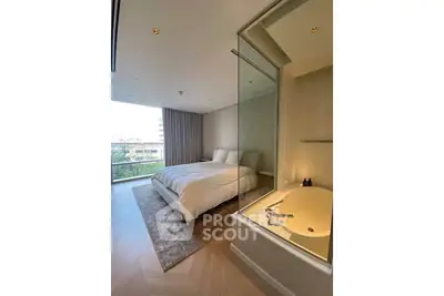 Luxurious bedroom with modern ensuite bathtub and large window view.