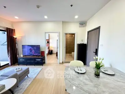 Modern open-plan living room with dining area, featuring elegant decor and natural light.
