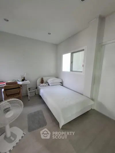 Cozy minimalist bedroom with white decor and workspace