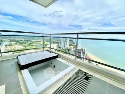 Luxurious balcony with private jacuzzi and stunning ocean view in high-rise apartment.