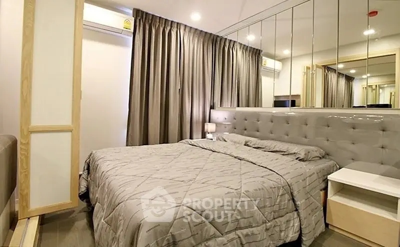 Modern bedroom with mirrored wall and elegant gray decor