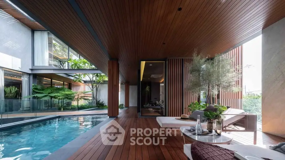 Luxurious modern poolside area with wooden deck and stylish outdoor furniture.