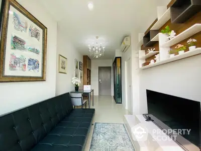 Modern living room with stylish decor and wall art, featuring a sleek black sofa and mounted TV.