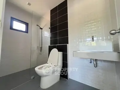 Modern bathroom with sleek design featuring a glass shower and contemporary fixtures.