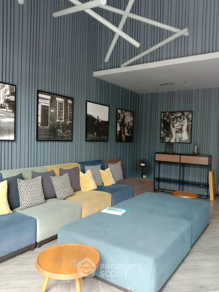 Stylish modern living room with blue sectional sofa and artistic wall decor
