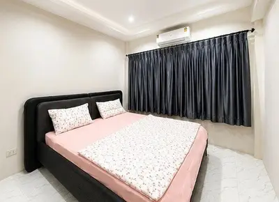 Cozy bedroom with modern decor and air conditioning, featuring a comfortable bed and elegant curtains.