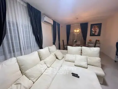 Elegant living room with plush white sofa and modern dining area