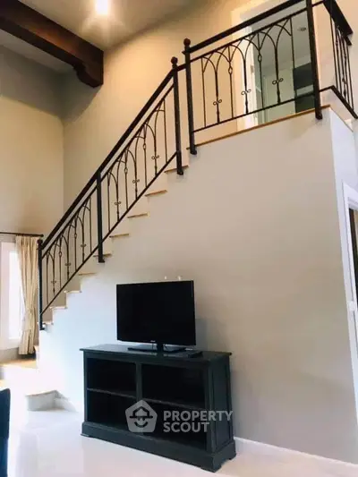 Elegant living room with stylish staircase and modern TV stand, perfect for contemporary homes.