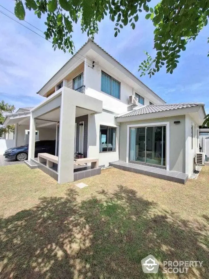 Modern two-story house with spacious lawn and sleek architectural design