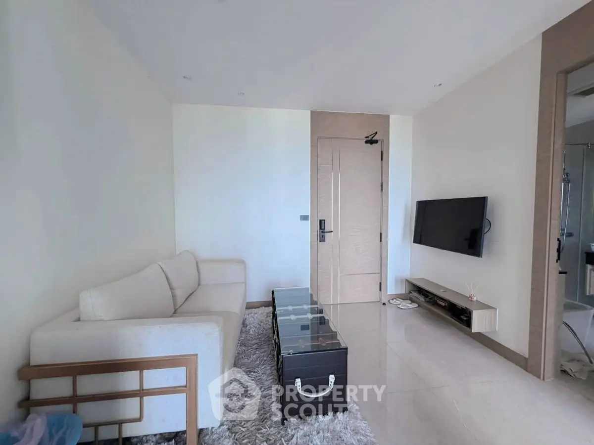 Modern living room with sleek furniture and wall-mounted TV in a stylish apartment.