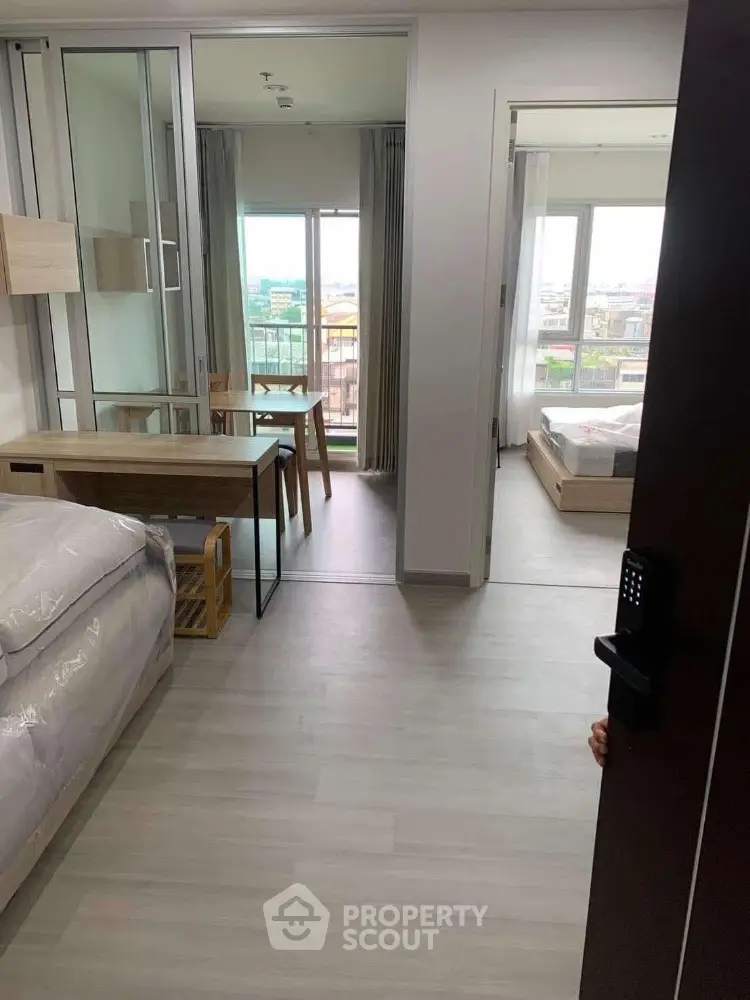 Modern apartment interior with open layout and large windows offering city views