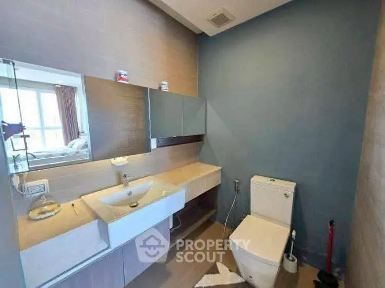 Modern bathroom with sleek fixtures and large mirror in bright apartment.