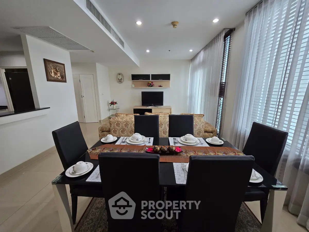 Elegant dining area with modern decor and natural light in a spacious living room.
