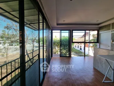 Spacious sunlit balcony with modern glass enclosure and scenic views