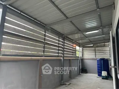 Spacious covered balcony with modern metal roofing and privacy screens