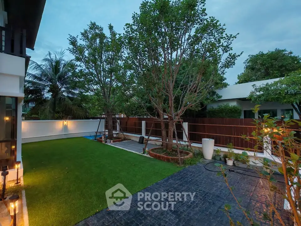 Spacious backyard with lush greenery and modern landscaping in a luxury home setting.