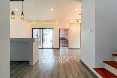 Modern open layout living space with stylish lighting and wooden flooring